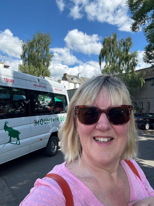 Tracy standing in front of a Mountain Goat mini bus