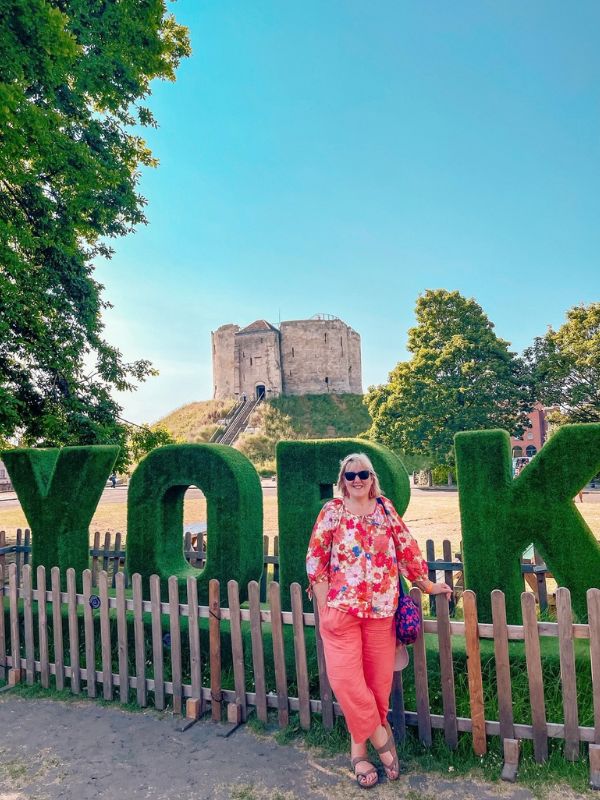 Tracy in front of a sign for York and Clifford's Tower